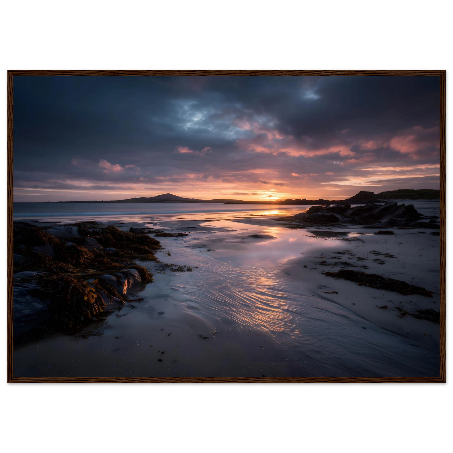 Dramatic coastal sunset print in a warm brown wood frame
