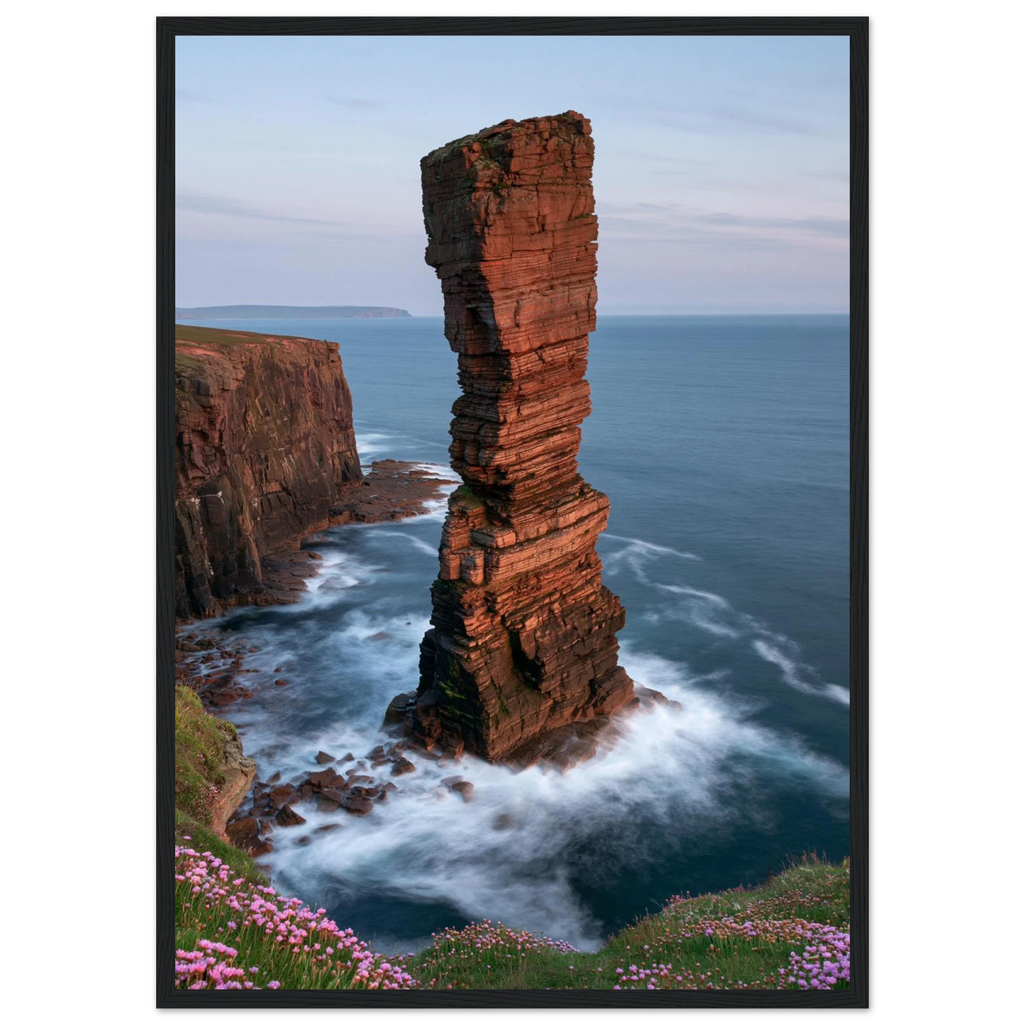 Red sandstone sea stack at last light above an Atlantic cliff coast, print in a black frame