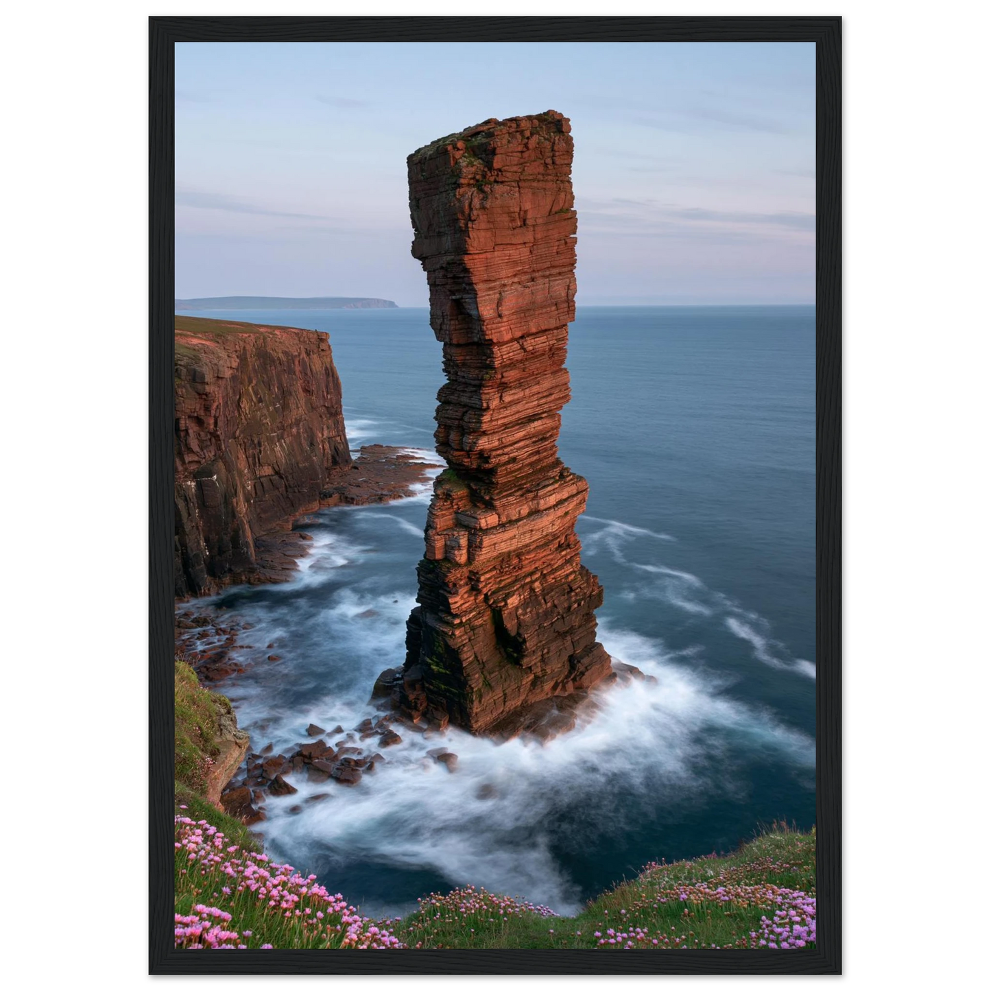 Red sandstone sea stack at last light above an Atlantic cliff coast, print in a black frame