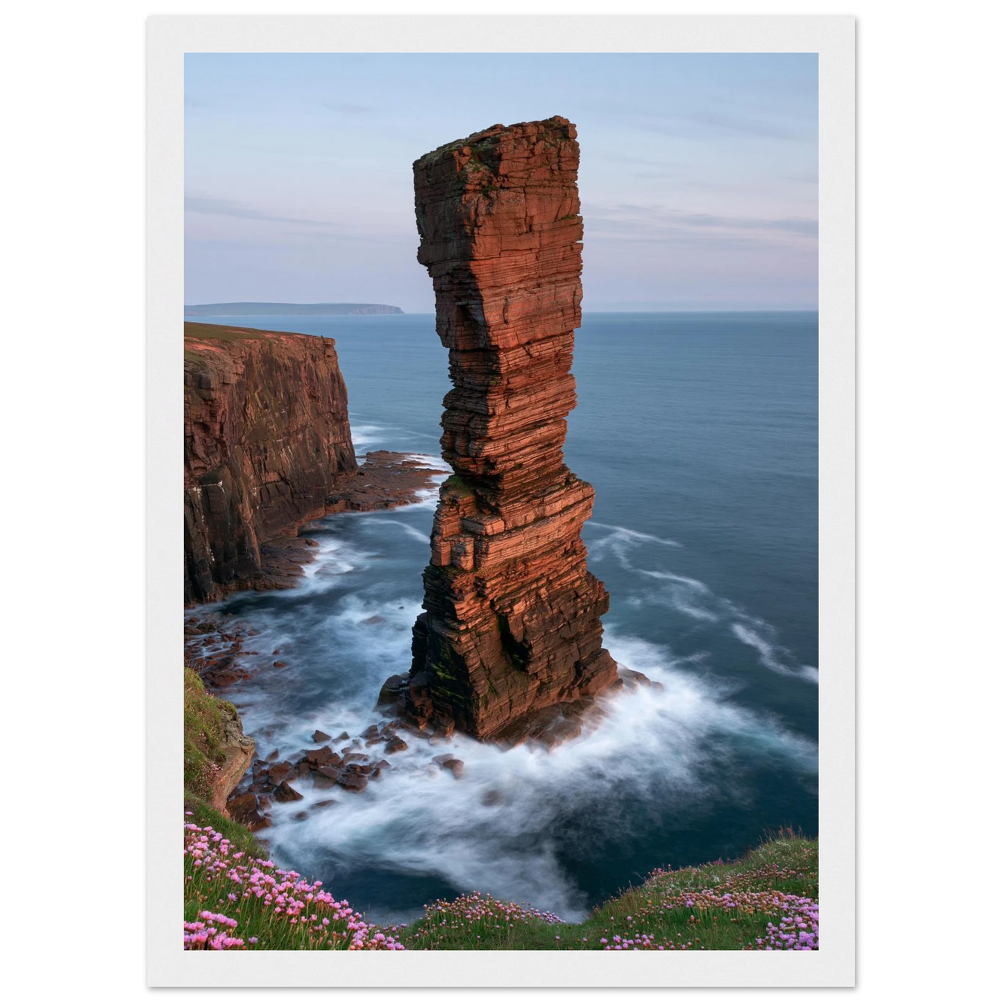 Red sandstone sea stack at last light above an Atlantic cliff coast, print in a white frame