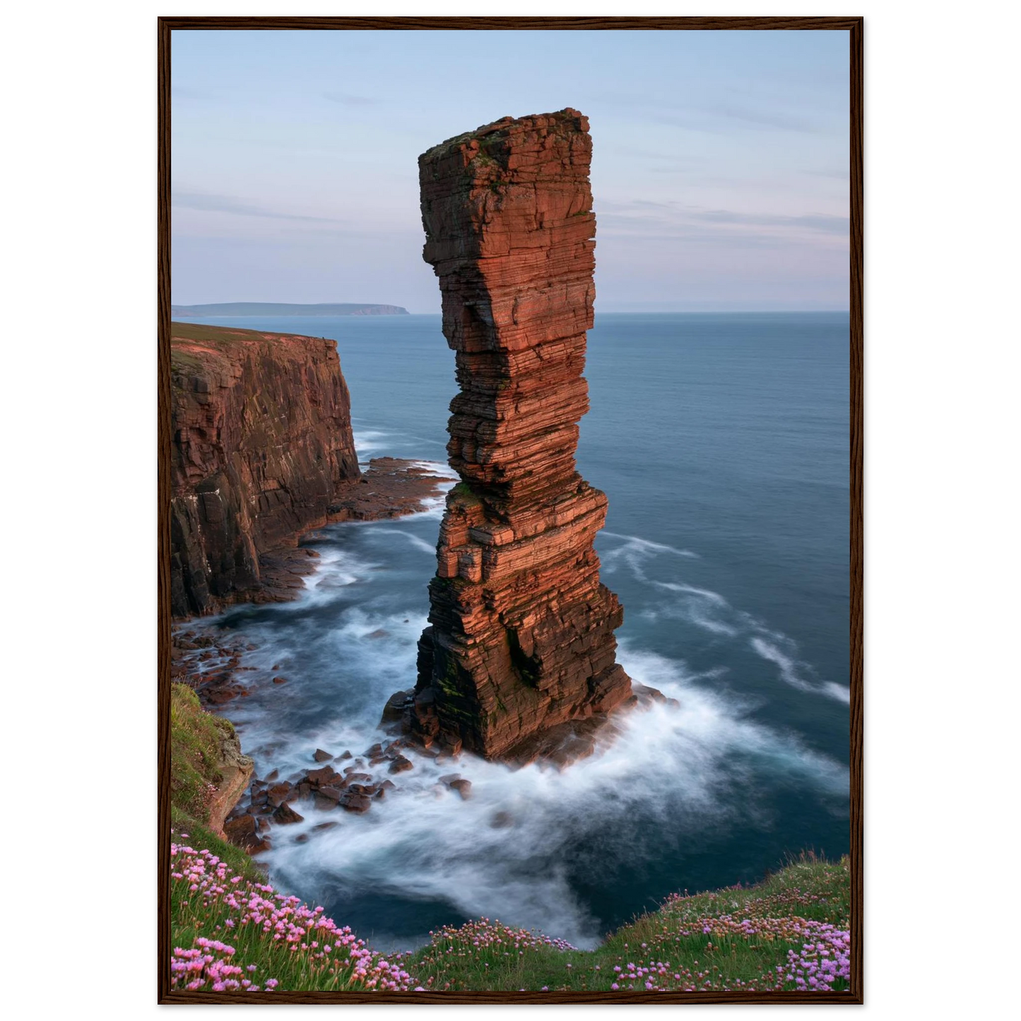 Red sandstone sea stack at last light above an Atlantic cliff coast, print in a dark brown wood frame