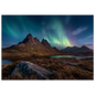 Green aurora above a dark mountain ridge and still water, in a light frame