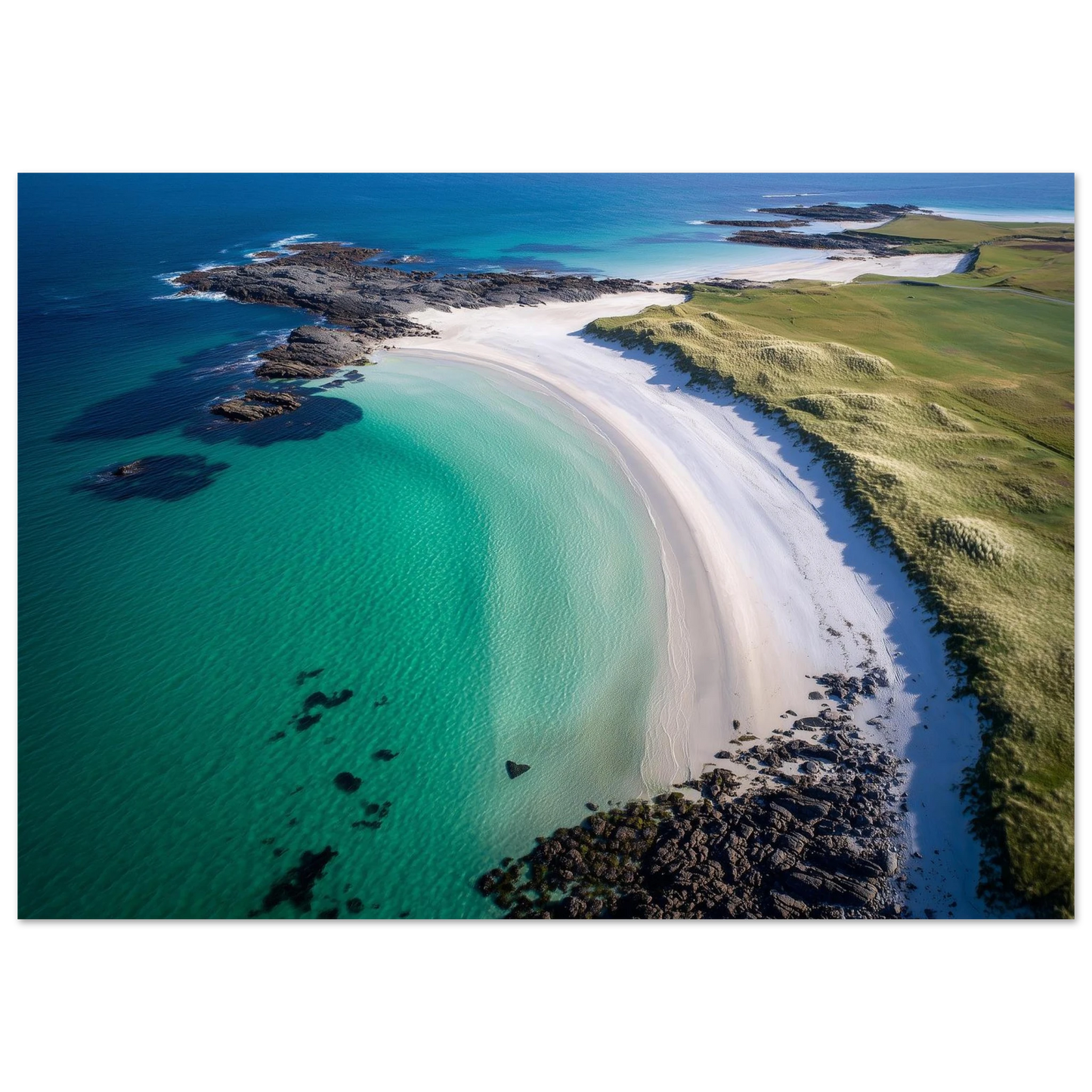 Aerial view of a curved white shell-sand beach with turquoise shallows, dark rocks and green machair, print in a slim dark frame