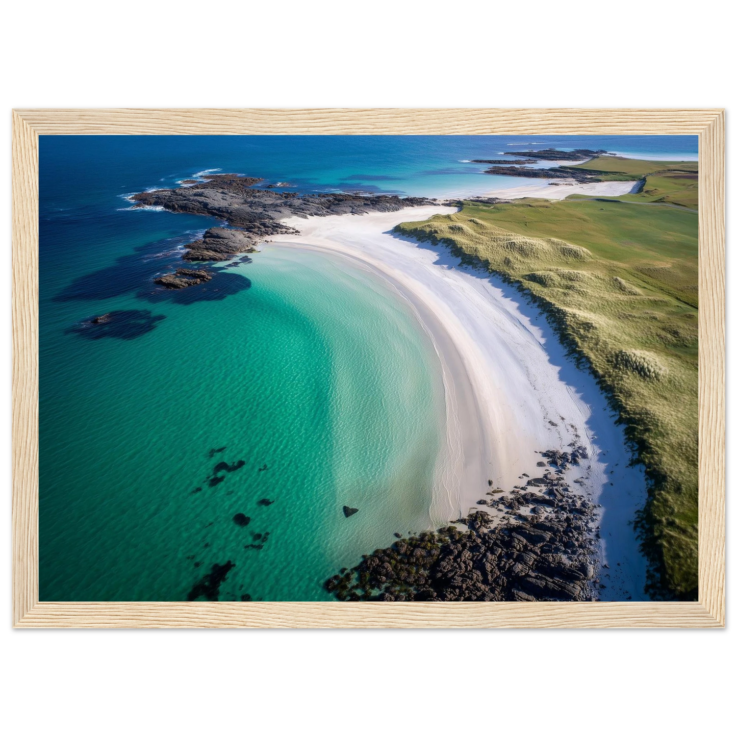 Curved beach and green machair from above, framed in pale oak with a wide mount