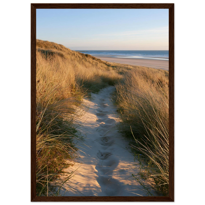 Sand track through amber marram grass to an empty beach at golden hour, print in a dark brown wood frame