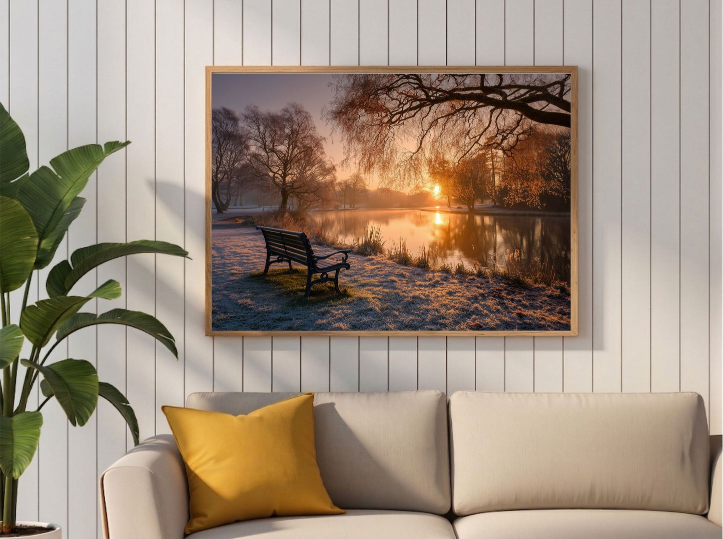 Frosted park lake at winter sunrise, framed in light wood above a cream sofa with a mustard cushion