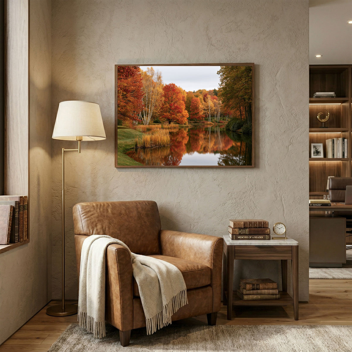 Autumn on the Lake, in a wood frame above a tan leather armchair in a reading corner