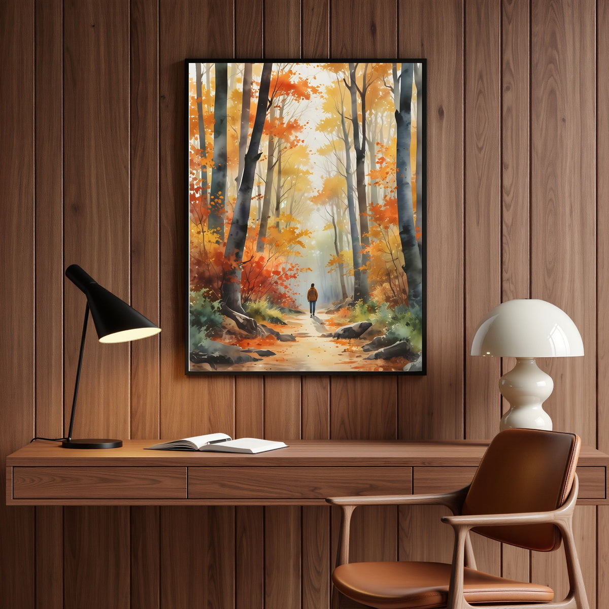 Autumn Woodland Path, in a black frame on warm wood panelling above a desk with a lamp in a home office