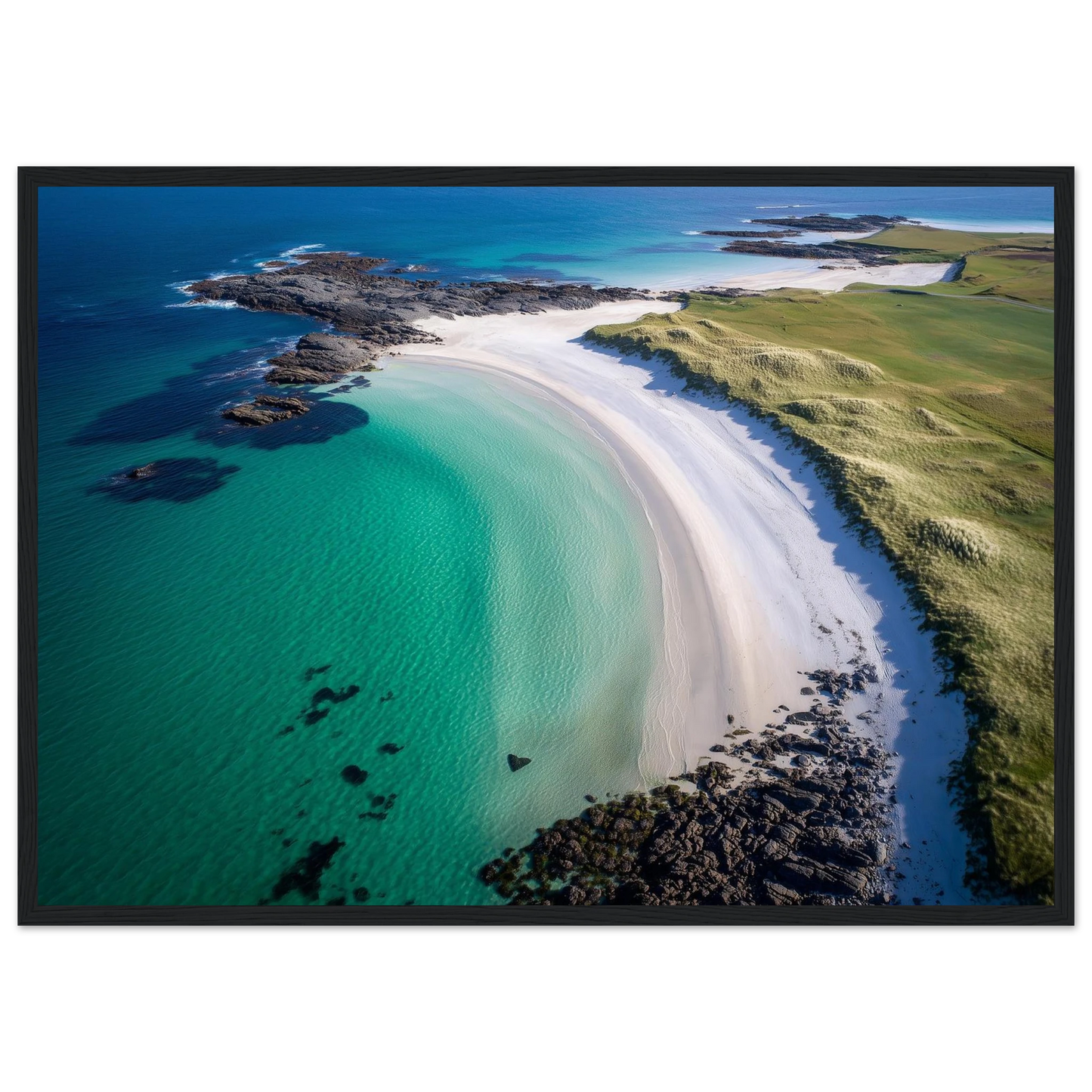 Aerial view of a white sand bay and green machair, framed in dark grey