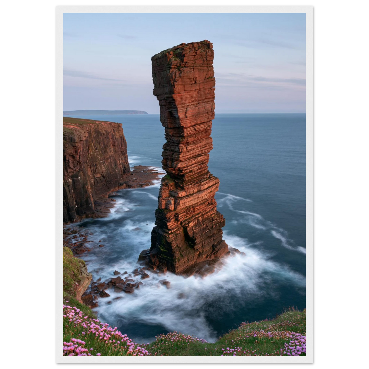 Red sandstone sea stack at last light above an Atlantic cliff coast, print in a white frame