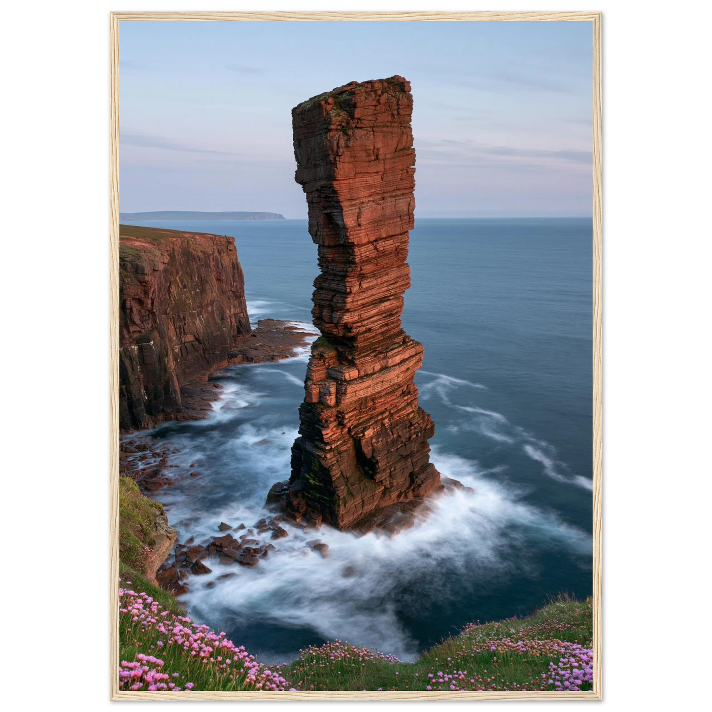 Red sandstone sea stack at last light above an Atlantic cliff coast, print in a natural light wood frame
