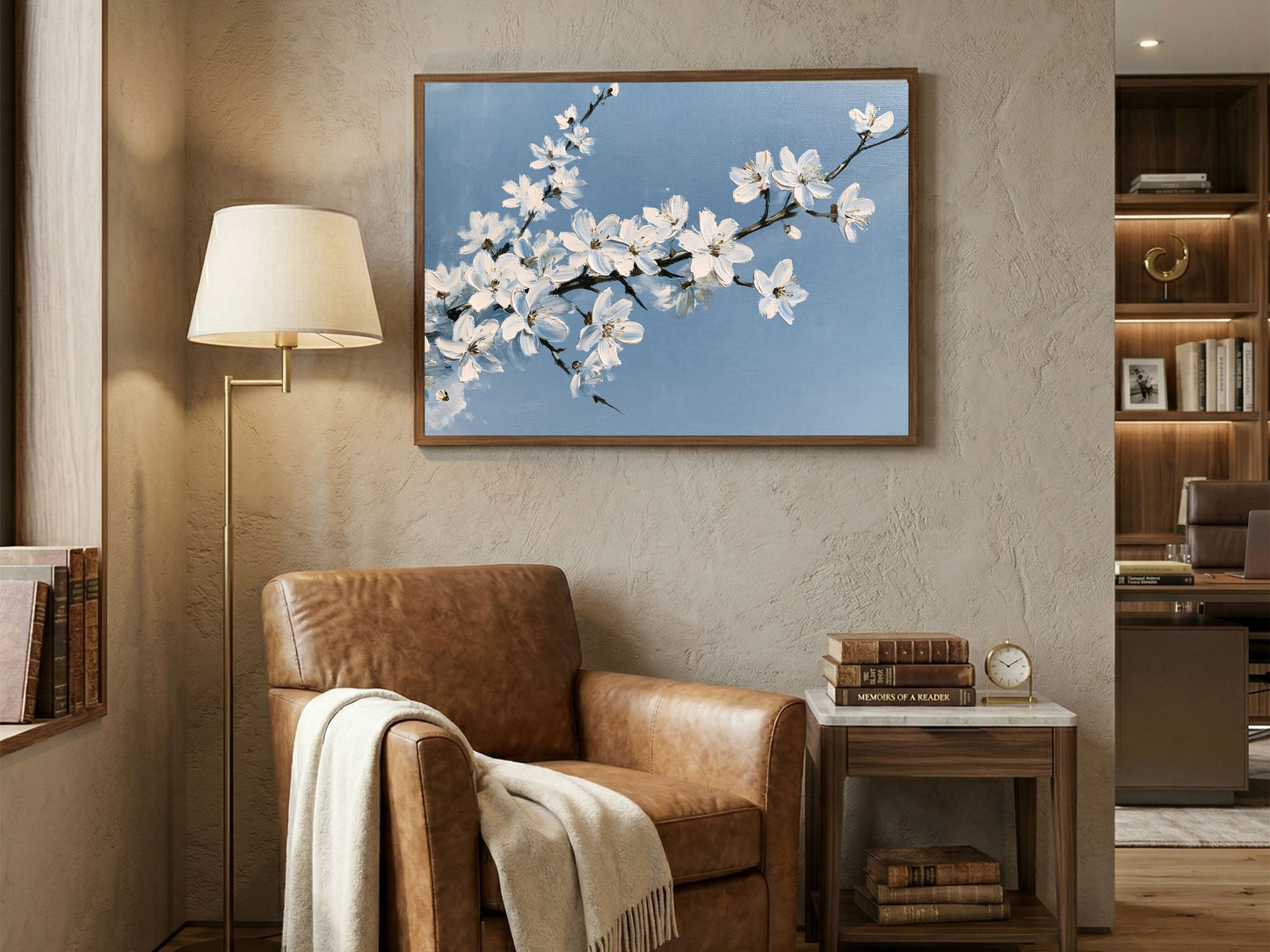 White blackthorn blossom against a pale blue sky in oil, hanging above a leather armchair in a reading corner