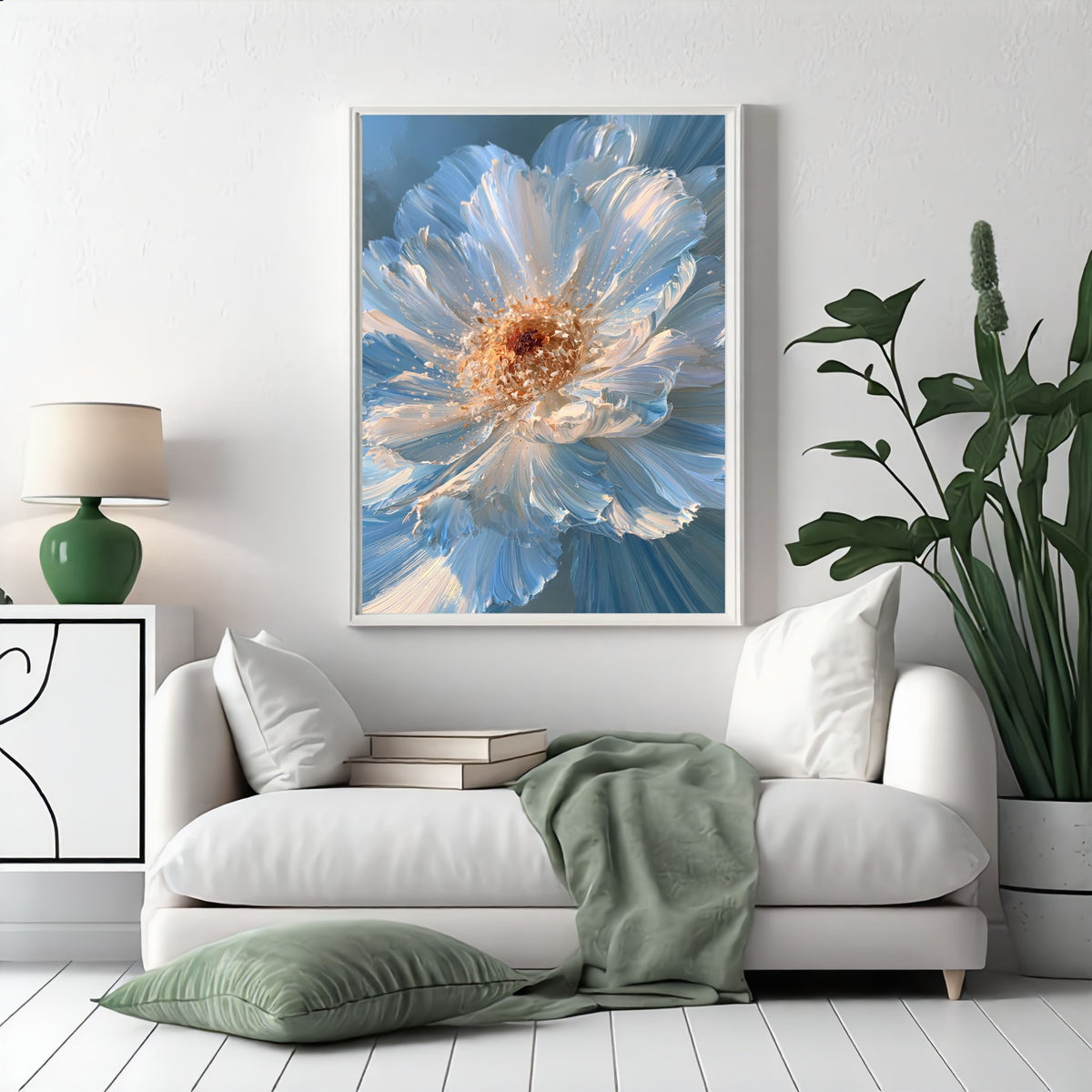 Blue impasto flower, in a white frame above a white sofa with a sage green throw and floor cushion in a bright living room
