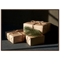 Kraft paper parcels tied with jute twine and spruce, print in a dark wood frame