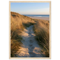 Sand track through amber marram grass to an empty beach at golden hour, print in a natural light wood frame