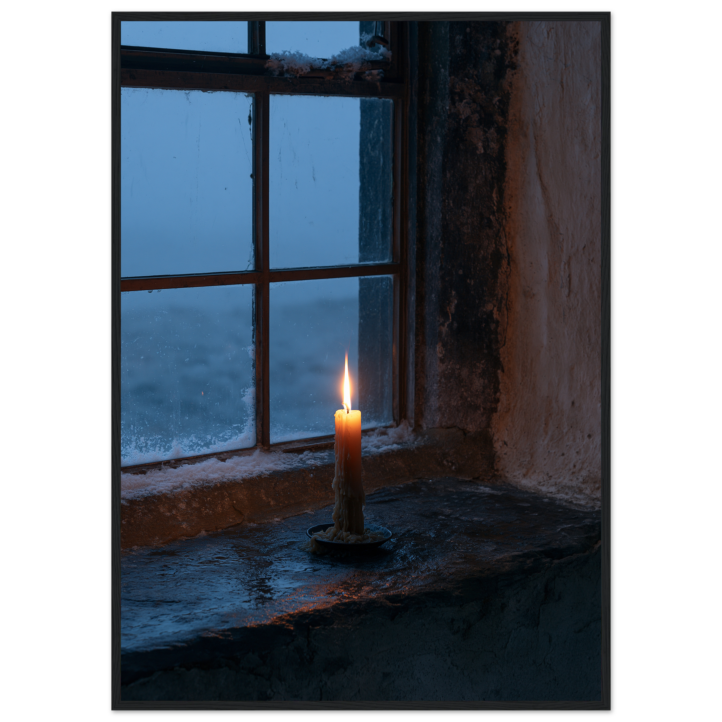 Candle burning on a stone windowsill at blue dusk, print in a black frame