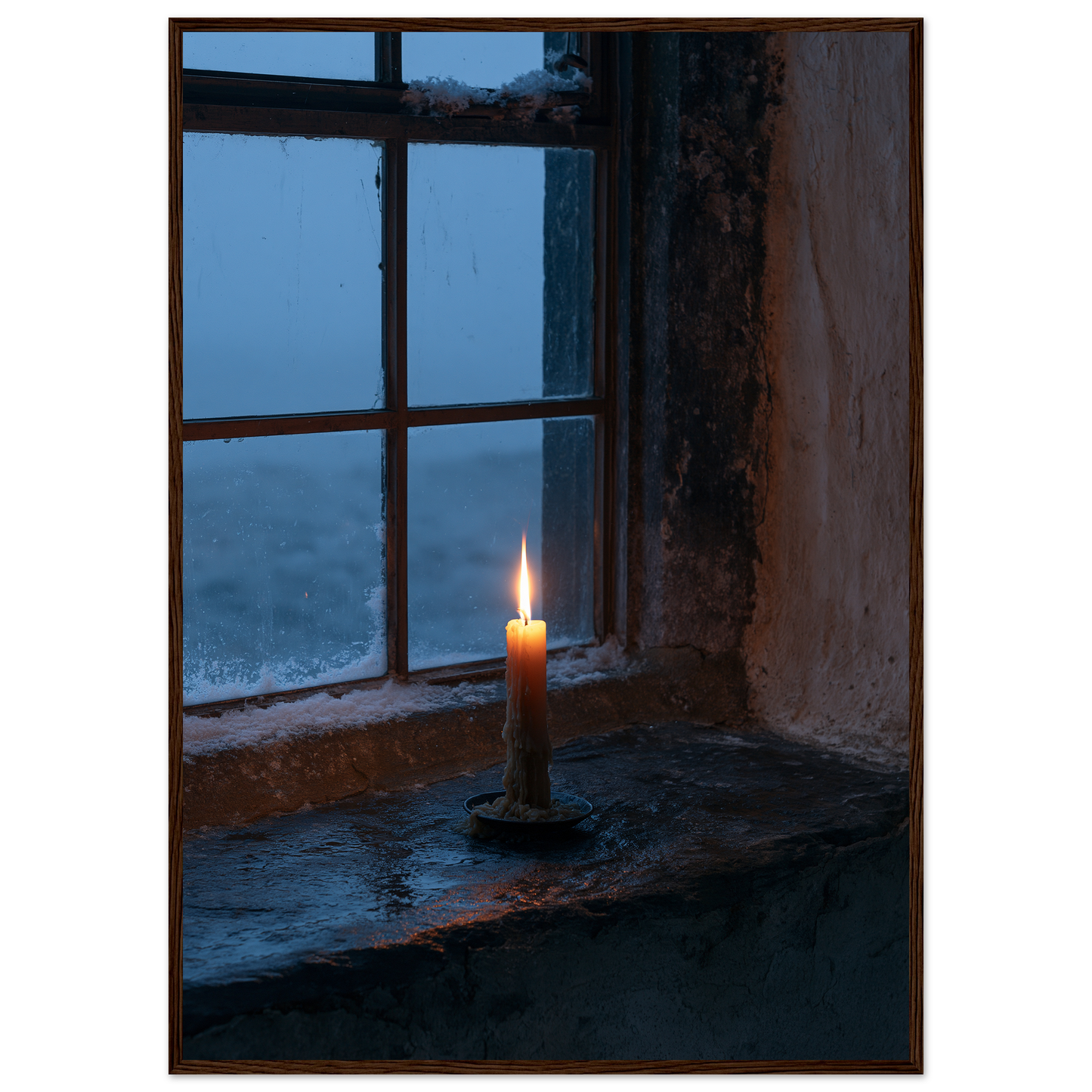Candle burning on a stone windowsill at blue dusk, print in a dark wood frame