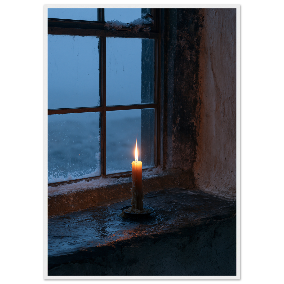Candle burning on a stone windowsill at blue dusk, print in a white frame