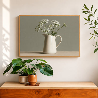 Cow parsley in a cream jug still life, print in an oak frame above a walnut sideboard in dappled morning light