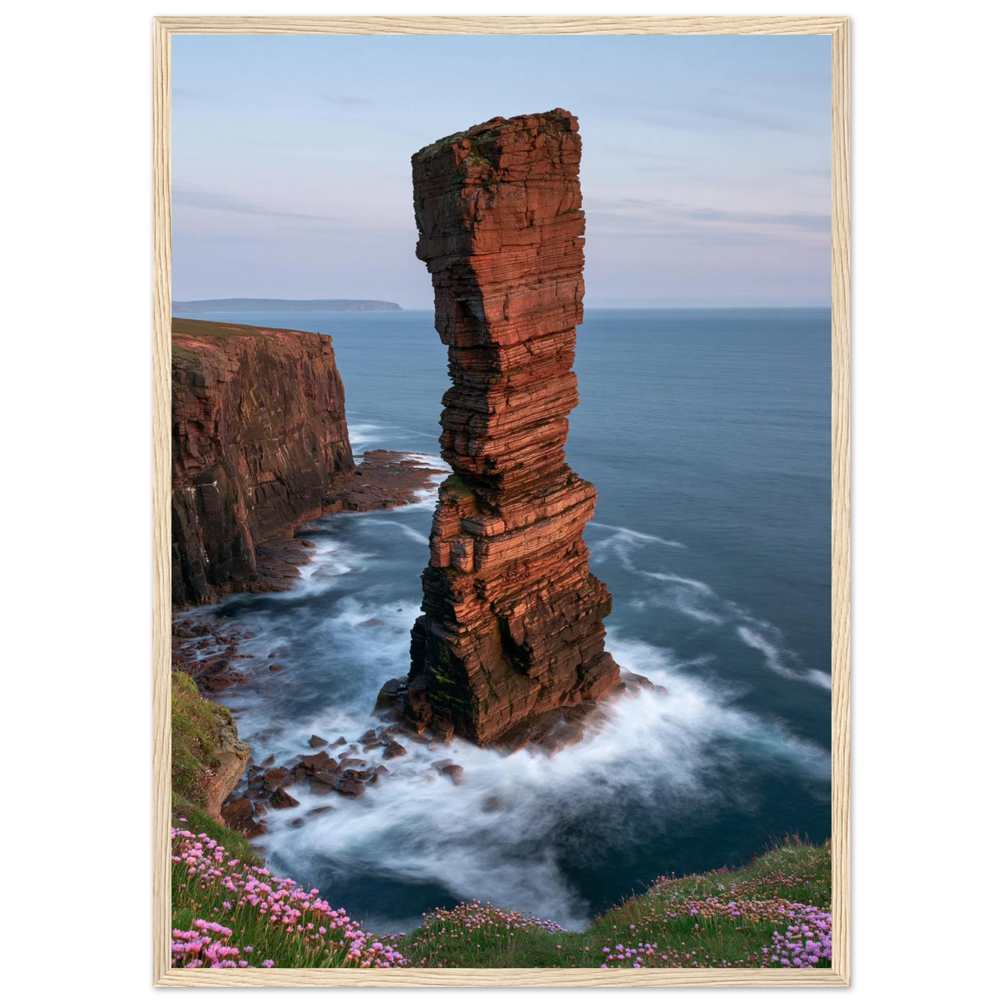 Red sandstone sea stack at last light above an Atlantic cliff coast, print in a natural light wood frame