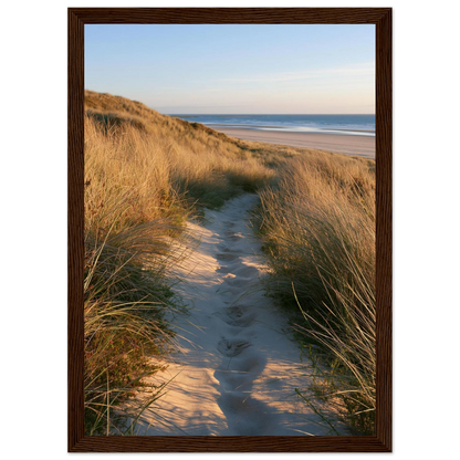 Sand track through amber marram grass to an empty beach at golden hour, print in a dark brown wood frame