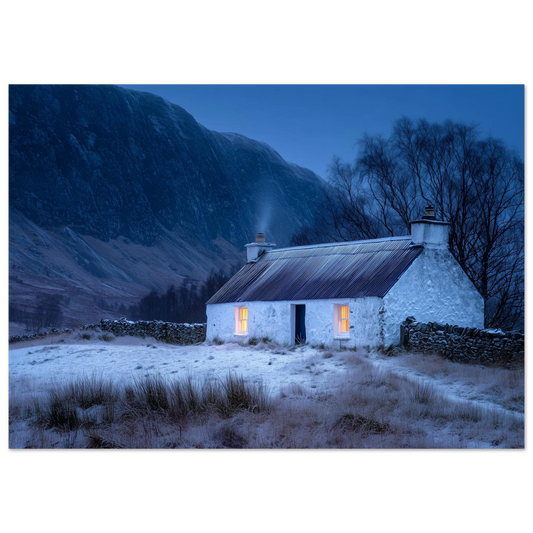 A whitewashed Highland croft with two lit windows at blue winter dusk, smoke from the chimney, drystone wall and snow-dusted mountain behind, in a slim dark frame
