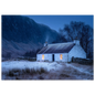 A whitewashed Highland croft with two lit windows at blue winter dusk, smoke from the chimney, drystone wall and snow-dusted mountain behind, in a slim dark frame