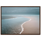 Calm tide line on an empty beach in soft blue and pink, framed in dark brown wood