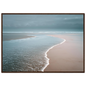Empty beach at the tide line in soft neutral tones, framed in warm dark wood