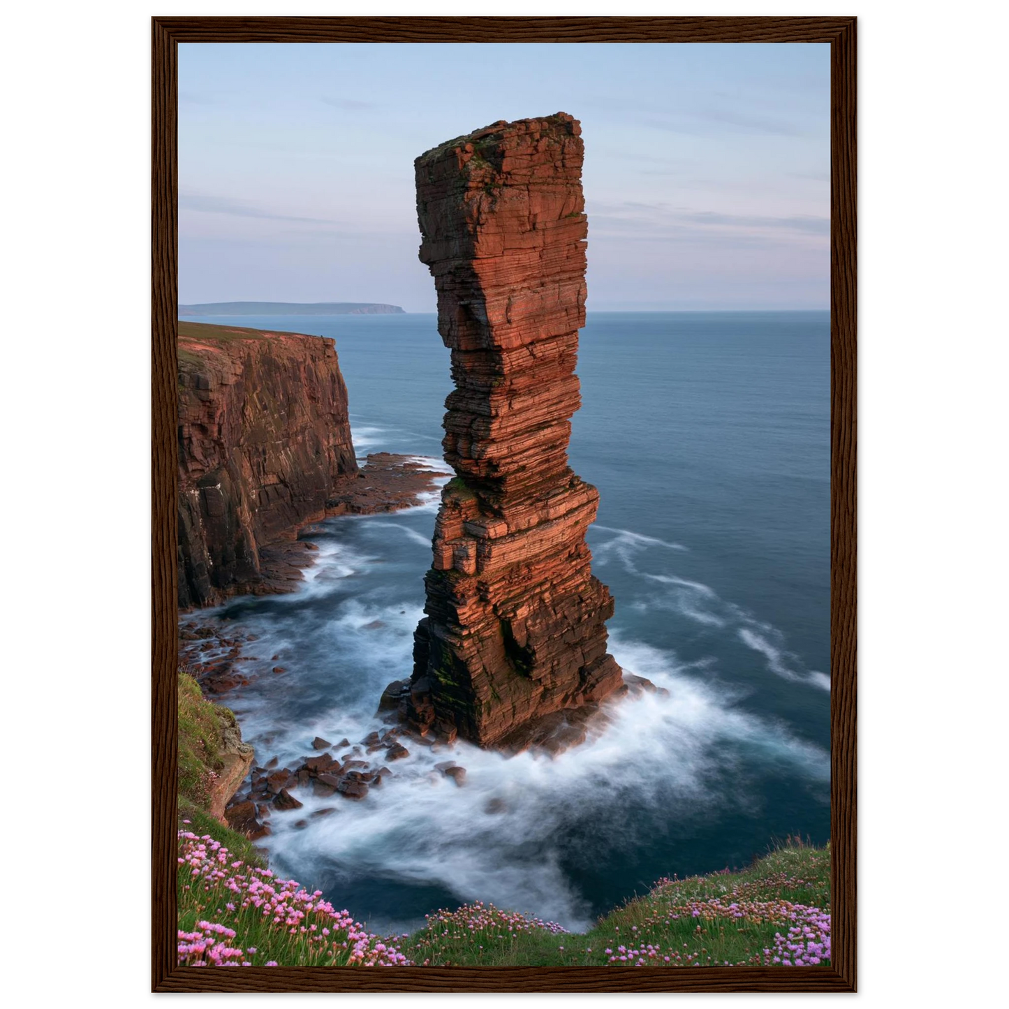 Red sandstone sea stack at last light above an Atlantic cliff coast, print in a dark brown wood frame