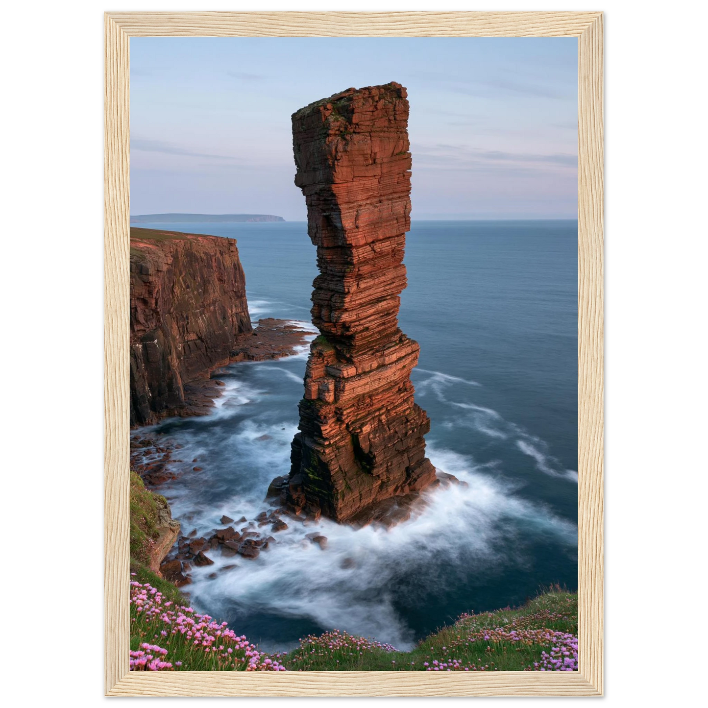 Red sandstone sea stack at last light above an Atlantic cliff coast, print in a natural light wood frame