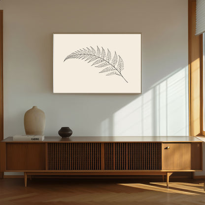 Fern frond line drawing on warm cream, print in a slim oak frame above a walnut sideboard in warm afternoon light
