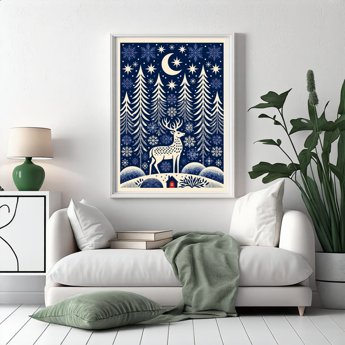 Folk-art winter glen, in a white frame above a white sofa with a sage green throw in a bright living room