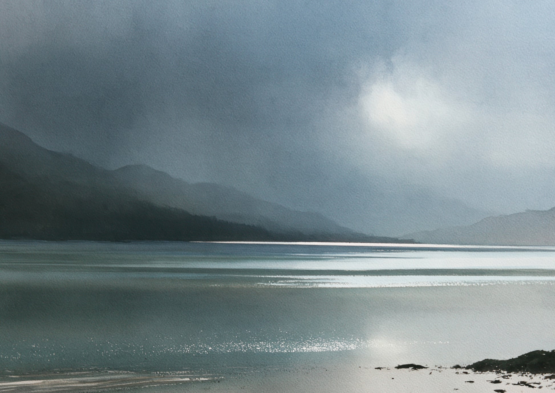 A Highland glen dissolving into rain, dark shore in the foreground and a band of silver light across the loch