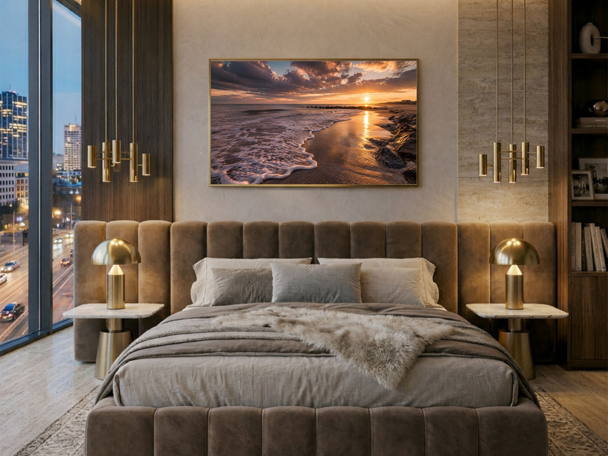 Beach at sunset with breaking waves and a low sun, framed in light wood above a velvet bed in a city apartment bedroom