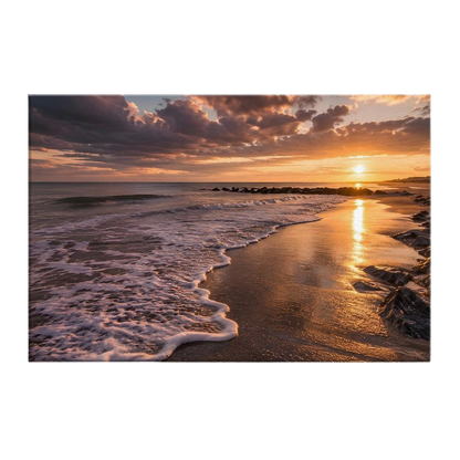 A low sun over a quiet shoreline with a long column of gold across wet sand, foam curving up the beach and a dark rock groyne to the right, printed on stretched canvas
