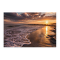 A low sun over a quiet shoreline with a long column of gold across wet sand, foam curving up the beach and a dark rock groyne to the right, printed on stretched canvas