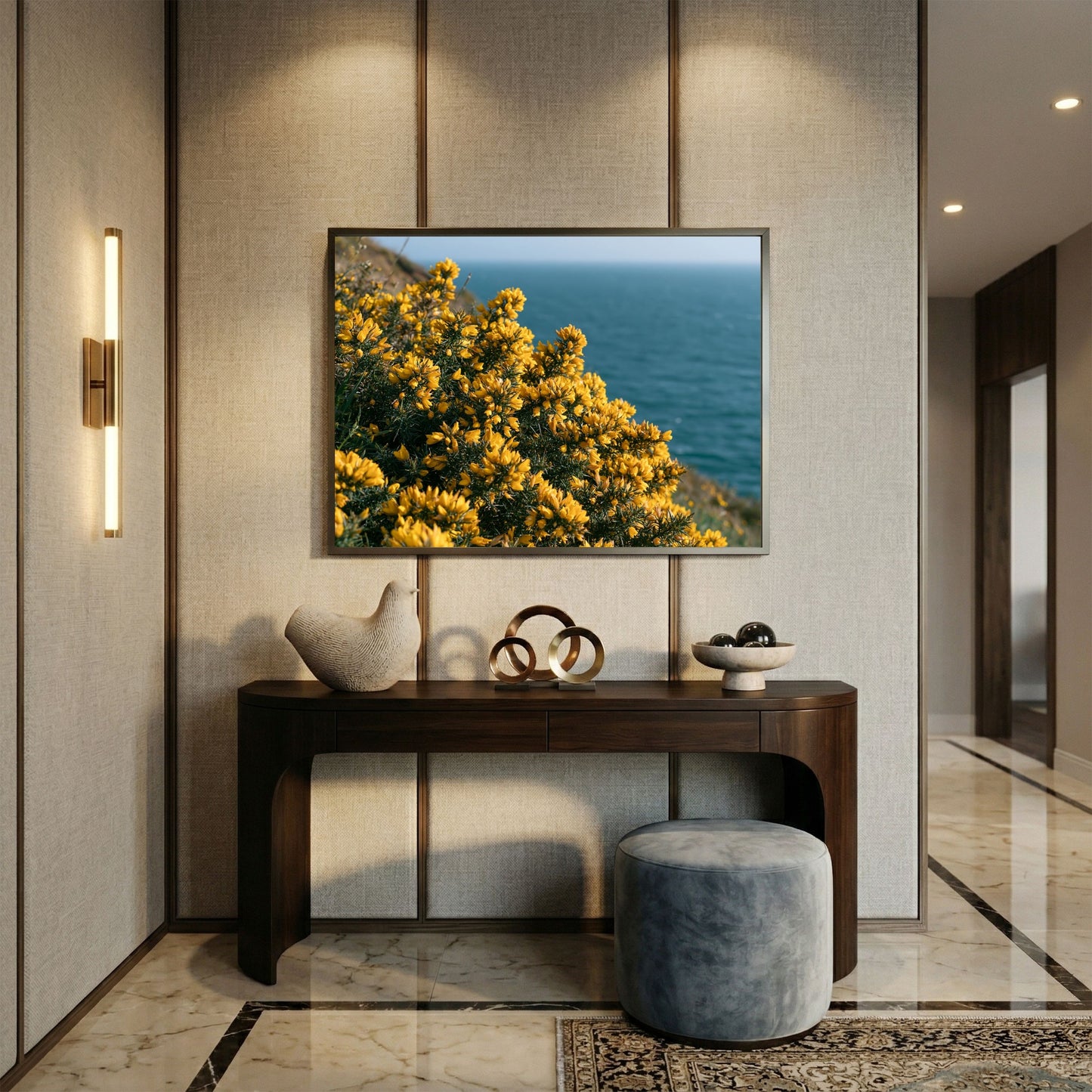 Golden gorse above a blue sea, print in a slim dark frame on a linen panelled hallway wall above a walnut console table
