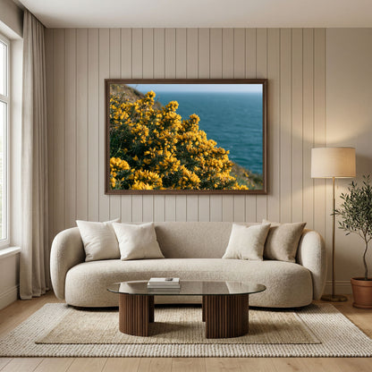 Golden gorse above a blue sea, print in a walnut frame above a cream boucle sofa in a panelled living room