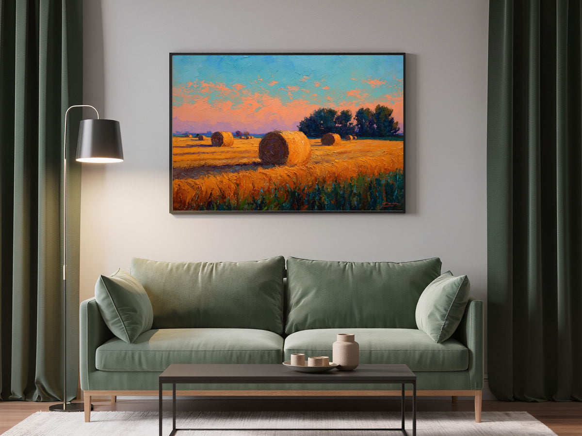 Impressionist harvest field of hay bales at sunset, in a dark frame above a sage green sofa