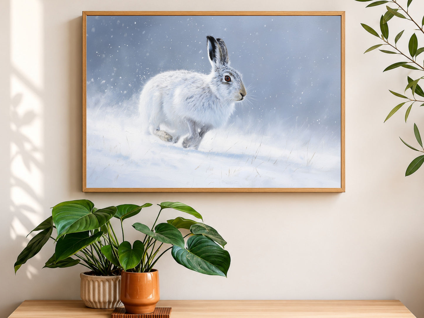 Mountain hare in falling snow, framed in light wood above an oak sideboard with houseplants in soft daylight