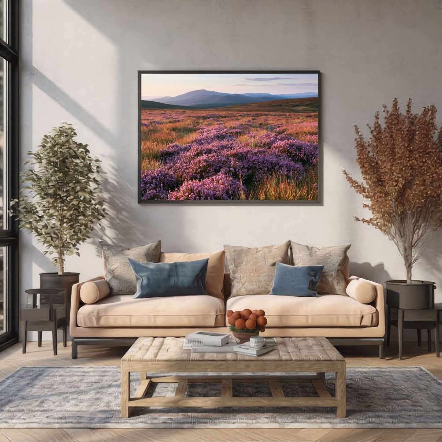 Purple heather moor below blue hills, print in a slim grey frame above a blush sofa in a bright modern living room