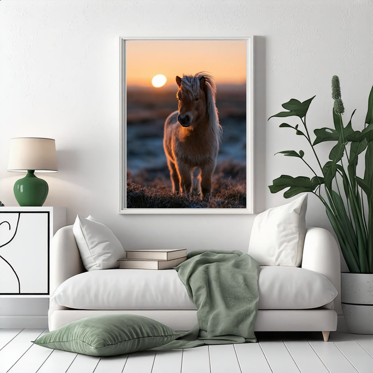 Shetland pony at sunset, in a white frame above a white sofa with a sage green throw in a bright living room