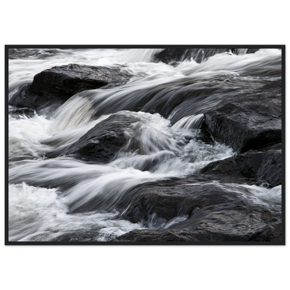 Silk water over dark rock, print in a black frame