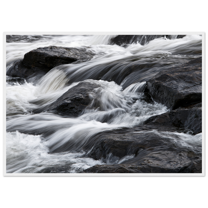 Silk water over dark rock, print in a white frame