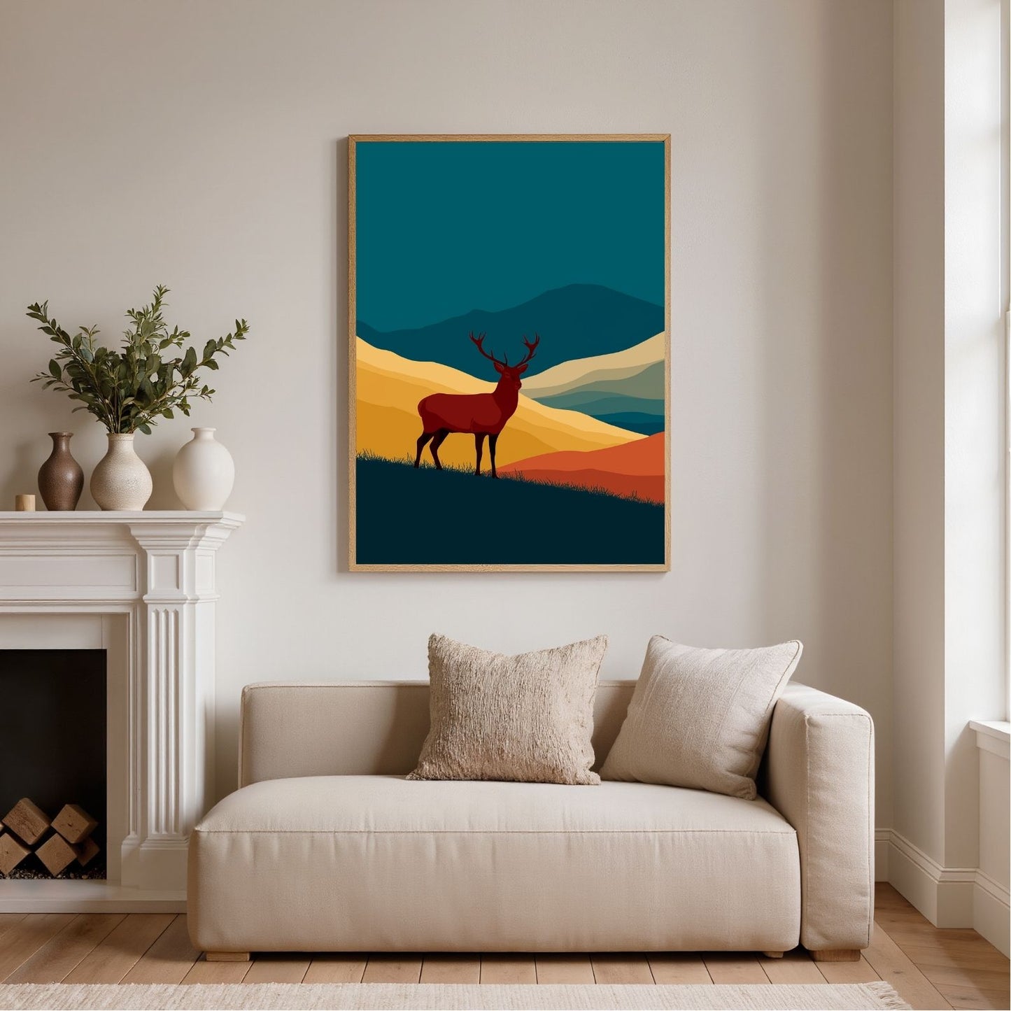 Teal and gold graphic stag above a Highland glen, framed in light wood above a cream sofa beside a white fireplace