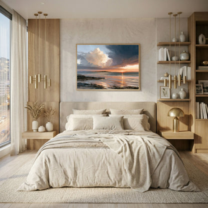 Storm light over the bay, in a natural wood frame above an oatmeal linen bed with brass pendant lights and wooden shelving in a bright bedroom