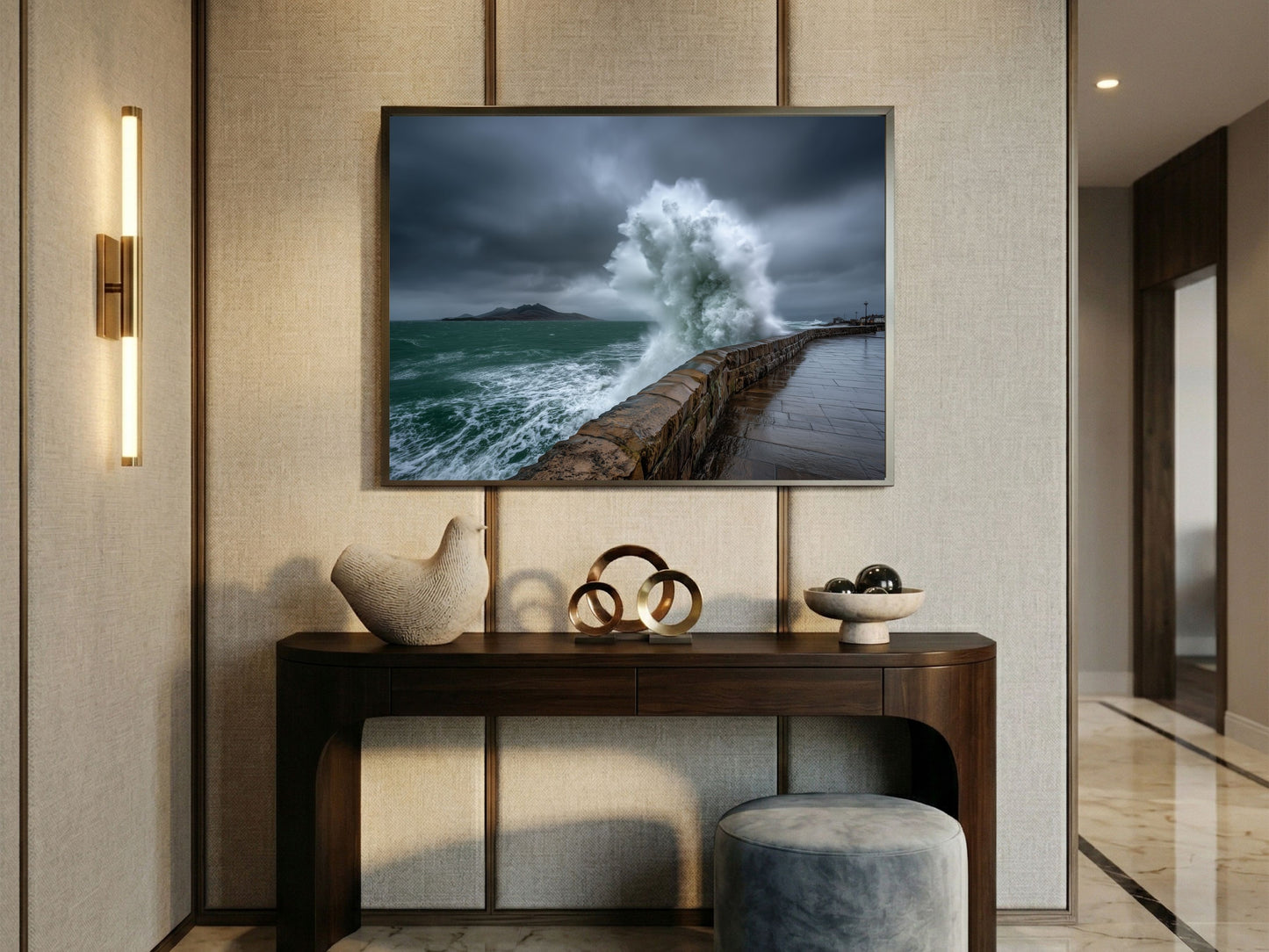 Storm wave bursting over a stone sea wall, framed above a console table in a panelled hallway