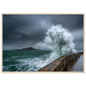 Storm wave bursting over a stone sea wall, print in a natural light wood frame