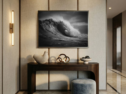 Black and white barrelling ocean wave, in a dark frame above a console table in a modern hallway